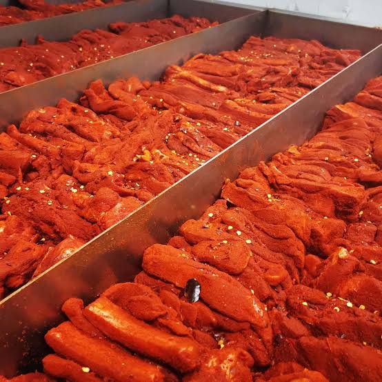 Pampanelle condite con peperoncino disposte in teglie da preparazione